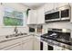 Well-lit kitchen featuring stainless steel appliances, granite countertops, and white cabinetry at 7033 Brecken Trce, Lithonia, GA 30058