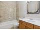 Bathroom with single sink vanity and combination tub and shower, with a rustic farmhouse mirror at 8010 Majors Mill Dr, Cumming, GA 30041