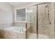 Bathroom featuring a tiled tub and shower with a window that provides natural light at 8010 Majors Mill Dr, Cumming, GA 30041