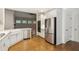 Bright kitchen with white cabinets, stainless steel appliances, and hardwood floors at 8010 Majors Mill Dr, Cumming, GA 30041