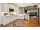 Well-lit kitchen featuring white cabinets, stainless appliances, and a view into the living room at 8010 Majors Mill Dr, Cumming, GA 30041