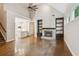 Bright living room featuring hardwood floors, fireplace with built-in shelving, and open access to the kitchen at 8010 Majors Mill Dr, Cumming, GA 30041