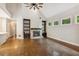 Bright living room featuring hardwood floors, fireplace with built-in shelving, and several windows at 8010 Majors Mill Dr, Cumming, GA 30041