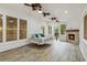 Bright sunroom with white shiplap walls, a hanging daybed, and a stone fireplace at 8010 Majors Mill Dr, Cumming, GA 30041