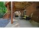 Covered back patio space with neutral seating, brick wall, and stairs leading to deck at 828 Ivy Ne Cv, Norcross, GA 30071