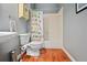 Neutral bathroom with wood floor, toilet, sink and shower/tub combination with paw print curtain at 828 Ivy Ne Cv, Norcross, GA 30071