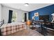 Comfortable bedroom featuring a bold blue accent wall, cozy carpet, and natural light from large windows at 828 Ivy Ne Cv, Norcross, GA 30071