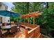 Elevated wooden deck featuring outdoor furniture, a pergola, and a view of lush greenery at 828 Ivy Ne Cv, Norcross, GA 30071
