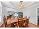 Open dining room with hardwood floors, view of the staircase, and modern chandelier at 828 Ivy Ne Cv, Norcross, GA 30071