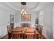 Elegant dining area featuring a tray ceiling, modern lighting, and wood floors at 828 Ivy Ne Cv, Norcross, GA 30071