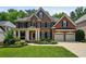 Stately brick home with well-manicured lawn, two car garage, and inviting covered front porch at 828 Ivy Ne Cv, Norcross, GA 30071