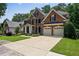 Stately brick home with a three-car garage, manicured lawn, and professional landscaping at 828 Ivy Ne Cv, Norcross, GA 30071