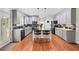 Bright, spacious kitchen featuring a center island with seating, stainless steel appliances, and hardwood floors at 828 Ivy Ne Cv, Norcross, GA 30071