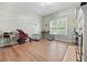 Cozy living room with hardwood floors, a large window, and a fireplace with white trim at 828 Ivy Ne Cv, Norcross, GA 30071