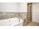 Bathroom features a large soaking tub with stone surround and a glass enclosed shower with tile at 133 Harold Dr, Mcdonough, GA 30253