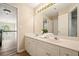 Neutral-toned bathroom featuring dual sinks, a large mirror, and white cabinets with gold hardware at 3130 Crestmont Nw Way, Kennesaw, GA 30152