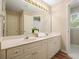 Bathroom with dual sinks, a large mirror, and white cabinets with brushed gold hardware at 3130 Crestmont Nw Way, Kennesaw, GA 30152