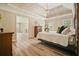 Serene main bedroom featuring tray ceilings, wood floors, and an open doorway at 3130 Crestmont Nw Way, Kennesaw, GA 30152