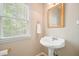 Charming powder room featuring a pedestal sink, gold-framed mirror, and a window at 3130 Crestmont Nw Way, Kennesaw, GA 30152