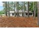 Well-maintained single-story home with black shutters surrounded by tall pine trees at 40 Melton Way, Covington, GA 30016