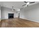 Open-concept living room featuring hardwood floors, a fireplace, and modern ceiling fans at 40 Melton Way, Covington, GA 30016