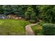 Lush backyard with stone walkway, waterfall feature, and mature trees at 7601 Watson Cir, Locust Grove, GA 30248