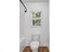 A well-lit bathroom with white toilet and tub surrounded by tile flooring and a bright window at 7601 Watson Cir, Locust Grove, GA 30248