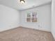 A simple room boasts neutral carpet, white walls, and a window with blinds at 7601 Watson Cir, Locust Grove, GA 30248