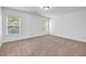 A sunny bedroom features neutral carpet, white walls, and two windows letting in natural light at 7601 Watson Cir, Locust Grove, GA 30248