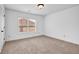A bright bedroom features neutral carpet, white walls, and a window letting in lots of natural light at 7601 Watson Cir, Locust Grove, GA 30248