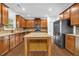 Well-lit kitchen boasts wooden cabinets, granite countertops, stainless steel appliances, and a large island at 7601 Watson Cir, Locust Grove, GA 30248