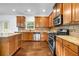 Well-equipped kitchen featuring hardwood floors, granite counters, stainless steel appliances, and wooden cabinets at 7601 Watson Cir, Locust Grove, GA 30248