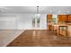 Open-concept living room featuring hardwood floors, large windows, and seamless access to a modern kitchen at 7601 Watson Cir, Locust Grove, GA 30248