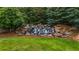 Serene backyard waterfall feature with landscaping and verdant trees at 7601 Watson Cir, Locust Grove, GA 30248