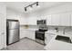 Beautiful, all-white kitchen offers stainless steel appliances and track lighting at 3108 Westchester Ne Rdg, Atlanta, GA 30329