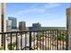 Balcony view of Atlanta skyline with high-rise buildings and a lush green landscape under a beautiful blue sky at 943 Peachtree Ne St # 2001, Atlanta, GA 30309