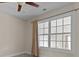 Bedroom featuring a ceiling fan and a large window with curtains at 2140 Wildcat Cliffs Way, Lawrenceville, GA 30043