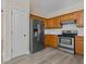 Well-lit kitchen showcasing stainless steel refrigerator, oven, and plentiful wooden cabinetry at 2140 Wildcat Cliffs Way, Lawrenceville, GA 30043