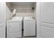 A bright laundry room featuring a washer and dryer, with ample space for sorting and folding at 2140 Wildcat Cliffs Way, Lawrenceville, GA 30043