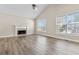 Bright living room featuring hardwood floors, a fireplace, and large windows for lots of natural light at 2140 Wildcat Cliffs Way, Lawrenceville, GA 30043