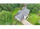 Aerial view of a two-story home with a well-manicured lawn, attached garage, and lush landscaping with stone border accents at 3085 Saint Andrews Dr, Duluth, GA 30096