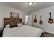 Bedroom featuring a comfortable bed, a wooden headboard, with guitars on the wall and view to hallway at 3085 Saint Andrews Dr, Duluth, GA 30096