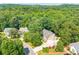 A captivating aerial view showcases the property amidst lush trees, highlighting its serene, private setting at 3440 Canyon Oak Way, Cumming, GA 30041