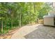 A gravel landscape and storage shed behind the house creates a practical outdoor space in the midst of natural greenery and trees at 3440 Canyon Oak Way, Cumming, GA 30041