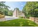 Spacious backyard showing the home's exterior, long driveway, basketball hoop, and fenced garden area for leisure and curb appeal at 3440 Canyon Oak Way, Cumming, GA 30041