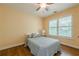 Cozy bedroom featuring hardwood floors, a ceiling fan, a shuttered window, and a charming, neutral color scheme at 3440 Canyon Oak Way, Cumming, GA 30041