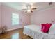 Charming pink bedroom with hardwood floors, a window with shutters, a ceiling fan, and classic trim details at 3440 Canyon Oak Way, Cumming, GA 30041