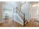 Open foyer featuring hardwood floors, a classic staircase with white railings and stained wood accents at 3440 Canyon Oak Way, Cumming, GA 30041