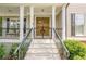 Charming front entrance featuring double wood doors, decorative ironwork, and white stairs leading to a cozy porch at 3440 Canyon Oak Way, Cumming, GA 30041