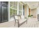 Inviting front porch with a comfortable wicker chair, decorative pillows and potted plants, enhancing curb appeal at 3440 Canyon Oak Way, Cumming, GA 30041